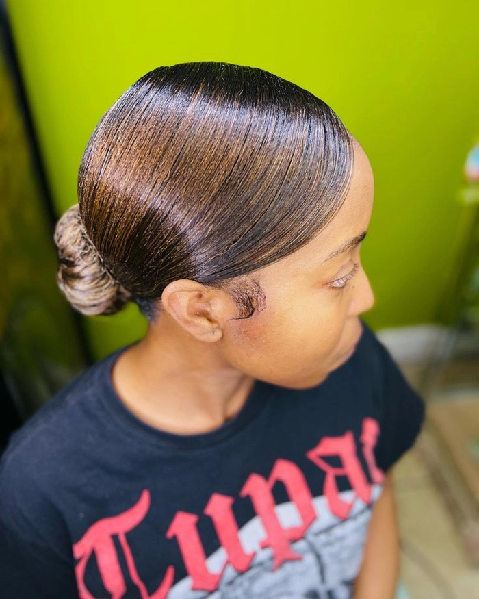 Image 7 of Work Hairstyles featuring a polished low bun with center part Sleek middle part low bun styled for executive presentations