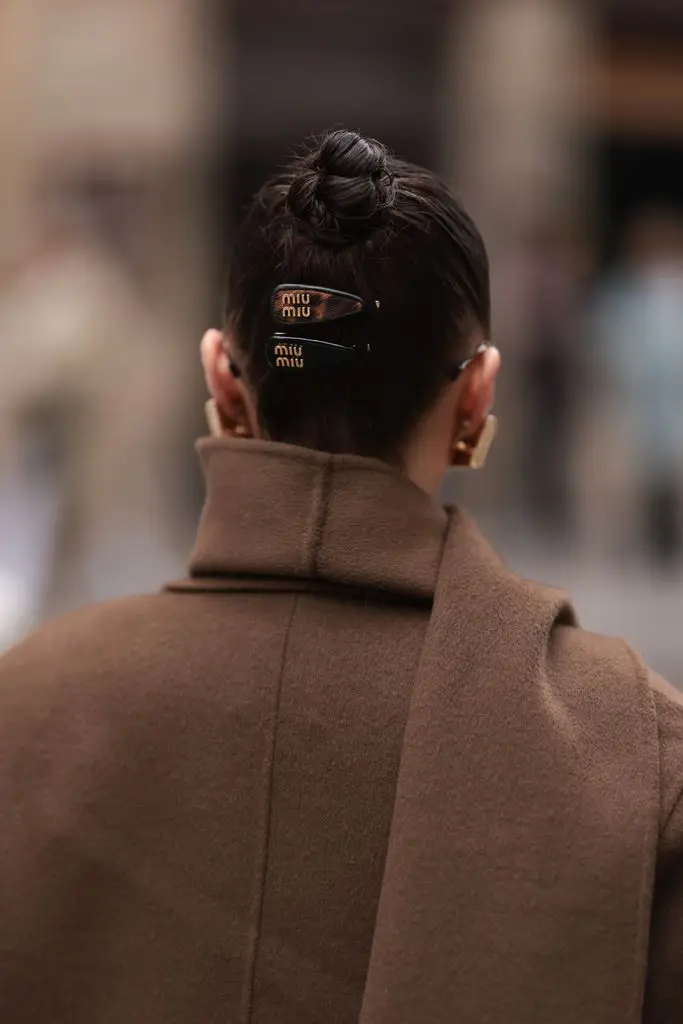 Minimalist hairpin placements for a sleek office bun, showing polished work hairstyle