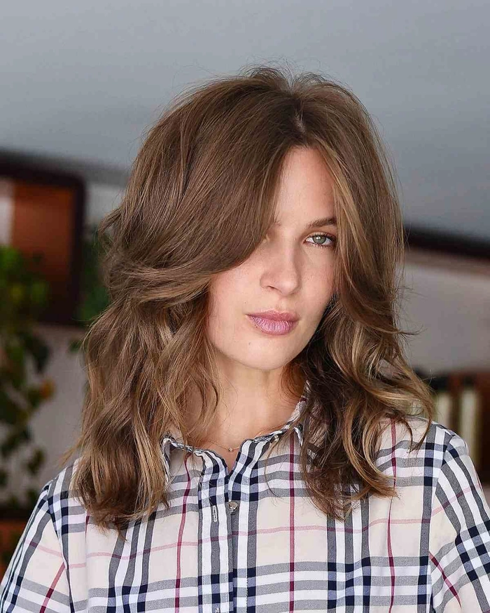 Soft bangs softening a square face shape in a professional office environment