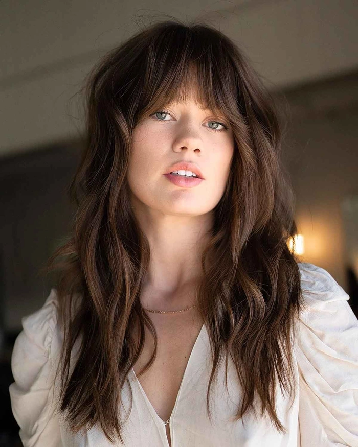 Professional woman with soft side-swept bangs softening a square face shape in a corporate office setting