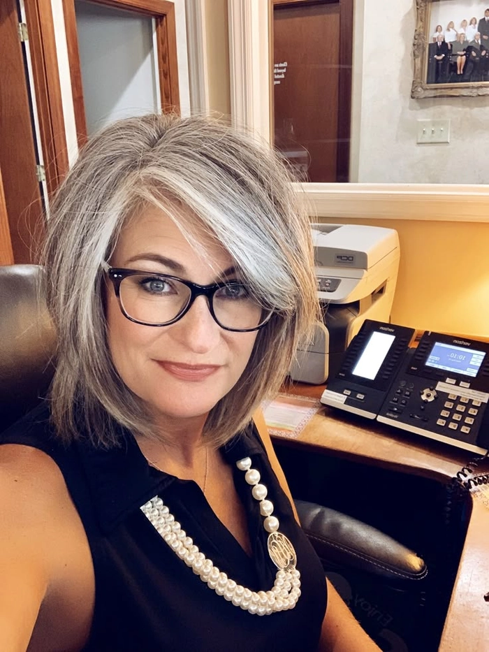 Sophisticated gray blending hairstyle for an older male executive in a professional office setting