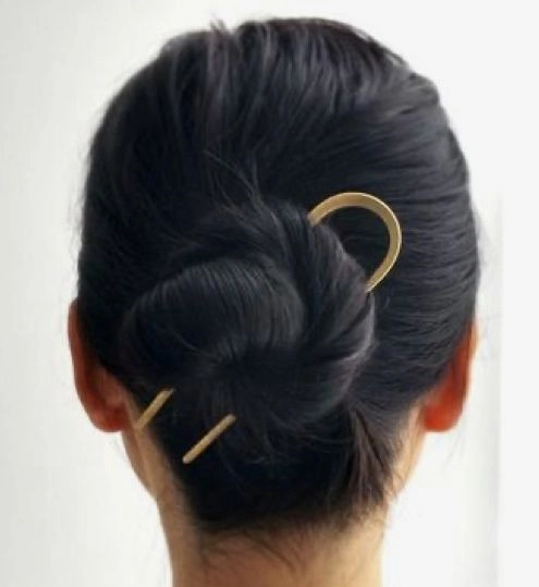 Subtle hair jewelry in a polished low bun with small pearl accents
