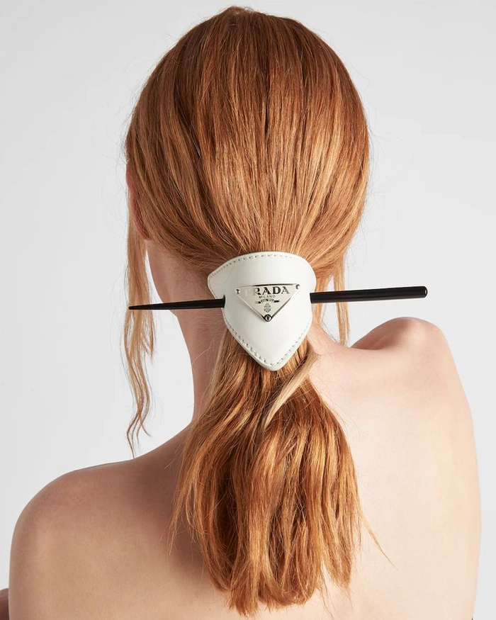Subtle gold hair pins accenting a neat low bun in a professional office setting