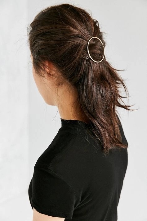 Female professional with small gold hair pins and a low bun in a business casual outfit