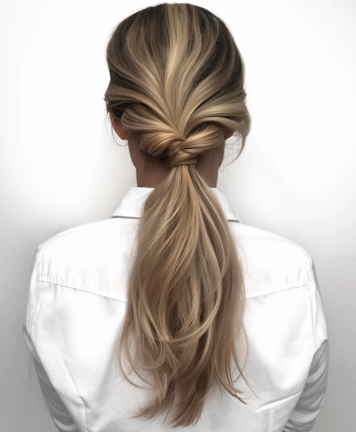 Woman with an elegant low bun and soft wisps, perfect for a cool summer office look