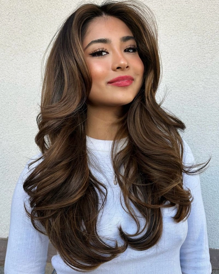 Sleek low bun with thick hair pinned neatly at a workspace desk