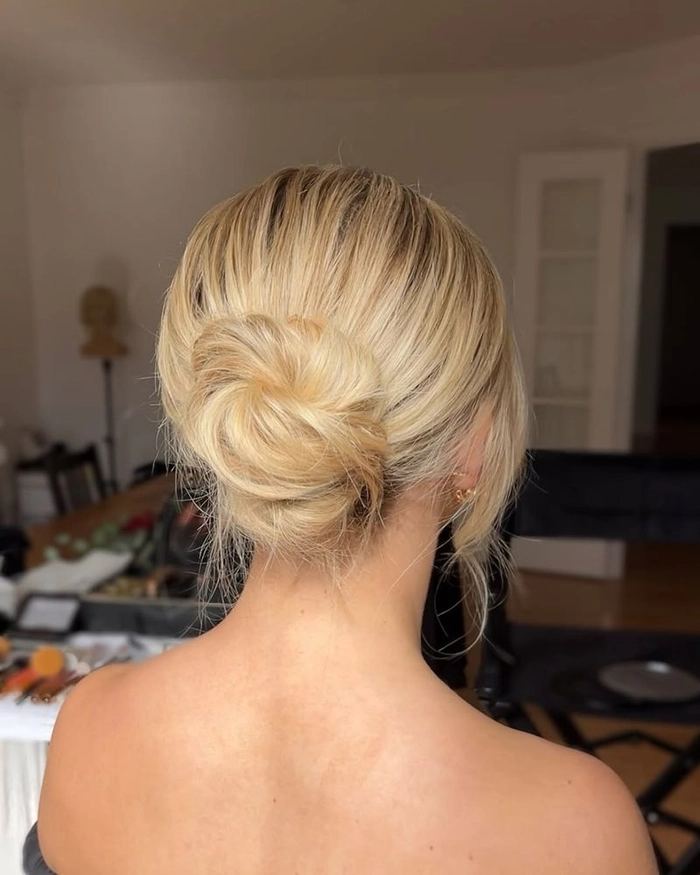 A sleek low bun keeps extra thick hair in place for a professional workspace hairstyle