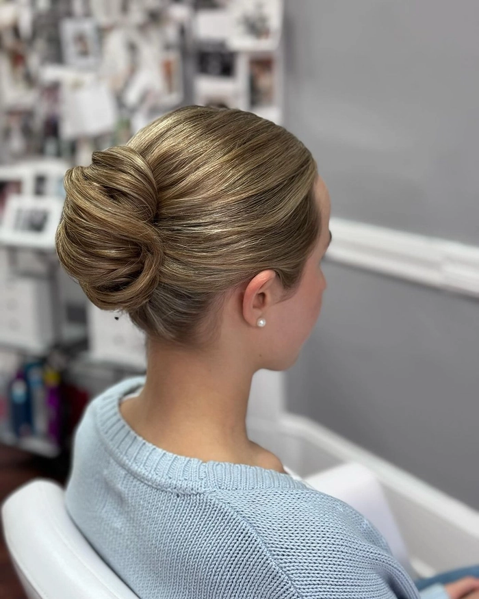 A polished yet relaxed low chignon with texture for creative professional settings