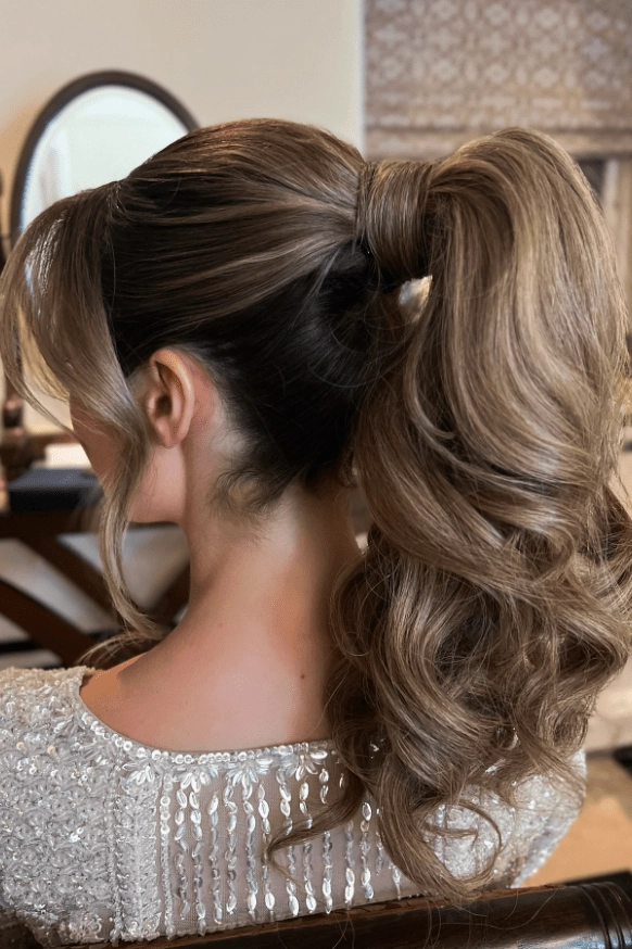 A woman quickly wrapping a ponytail accessory for an early work shift