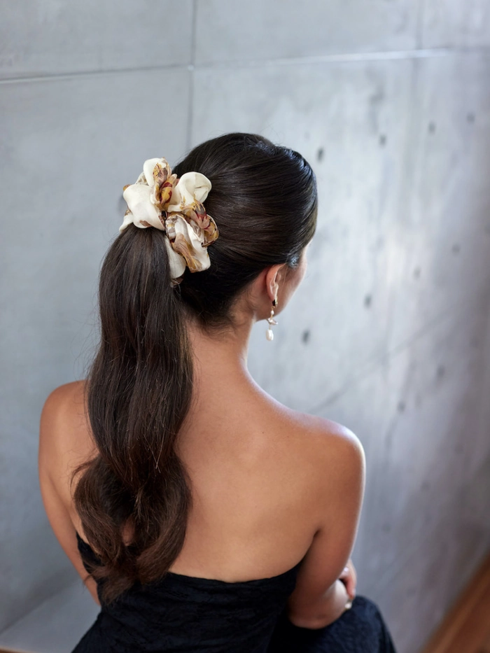Elegant velvet scrunchie ponytail style perfect for professional office settings A sophisticated velvet scrunchie securing a low ponytail for a polished business casual work hairstyle