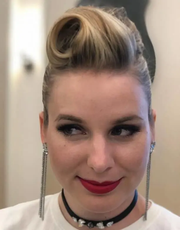 Model with classic rolled victory rolls hairstyle suitable for a retro themed work event