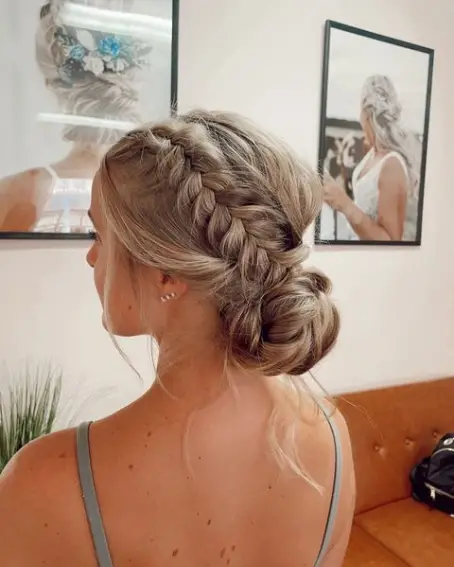 Wind Resistant Hairstyles for Outdoor Corporate Events - Work Hairstyles Image 10 A professional woman with a sleek low bun and bobby pins smiling confidently at an outdoor corporate event with a gentle breeze